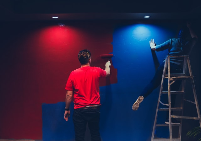 Man and a woman painting a wall 